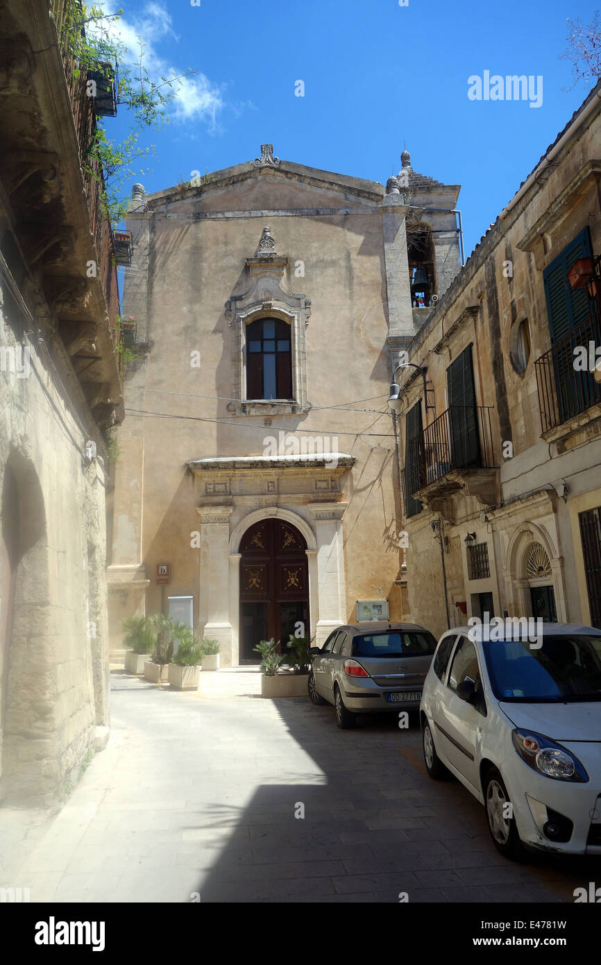 Ragusa, Sicilly- affascinanti e pittoreschi tetti di terracotta, le campane della chiesa, un medley di ristoranti strade strette causano il parcheggio auto Foto Stock