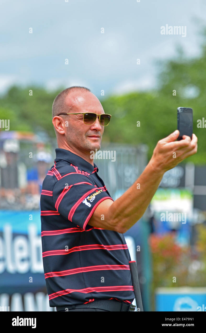 Celtic Manor, UK. 04 Luglio, 2014. Pratica per celebrità a la celebrità Cup, Celtic Manor, sul primo tee. TV Celebrity Andrew Howard visto il controllo della yardage prima di rinvio off sul 1st. Credito: Robert Timoney/Alamy Live News Foto Stock