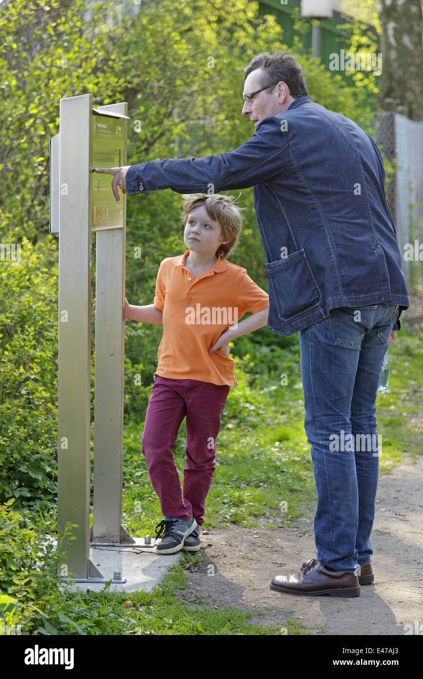 Padre spiegando Ploener Planetenpfad (Planet via di Ploen) per il suo piccolo figlio, Ploen, Schleswig-Holstein, Germania Foto Stock
