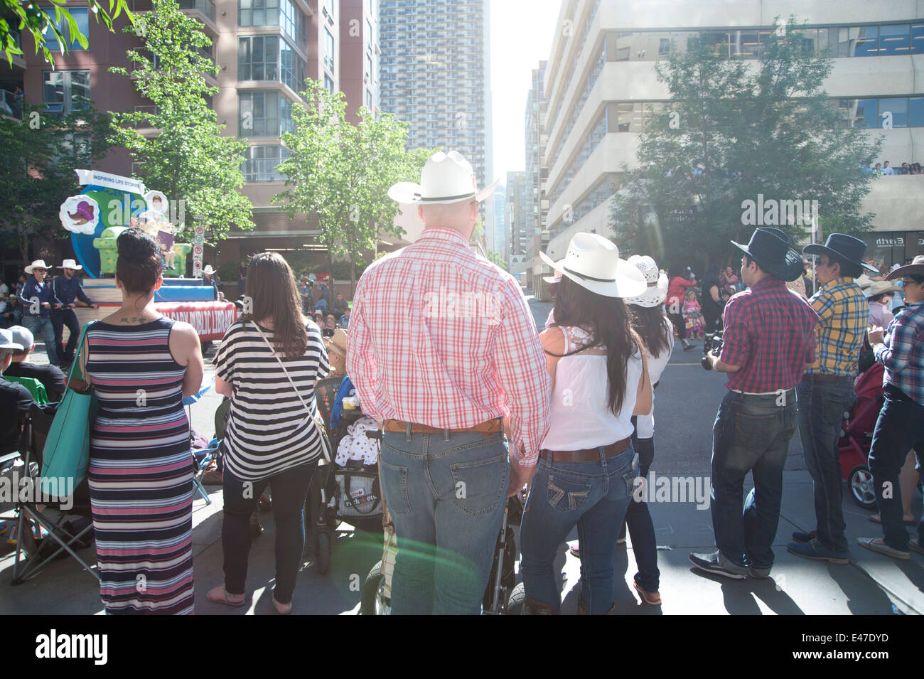 Persone in cappelli da cowboy lungo le strade di Calgary, Alberta Canada per la Parata di Stampede su un giorno di estate Foto Stock