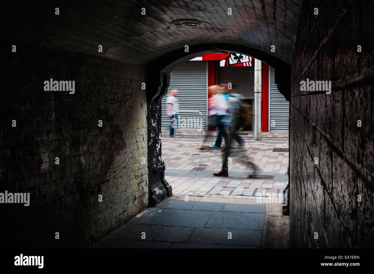 La gente a piedi passato Pottinger ingresso del tunnel in Belfast City Centre. Foto Stock