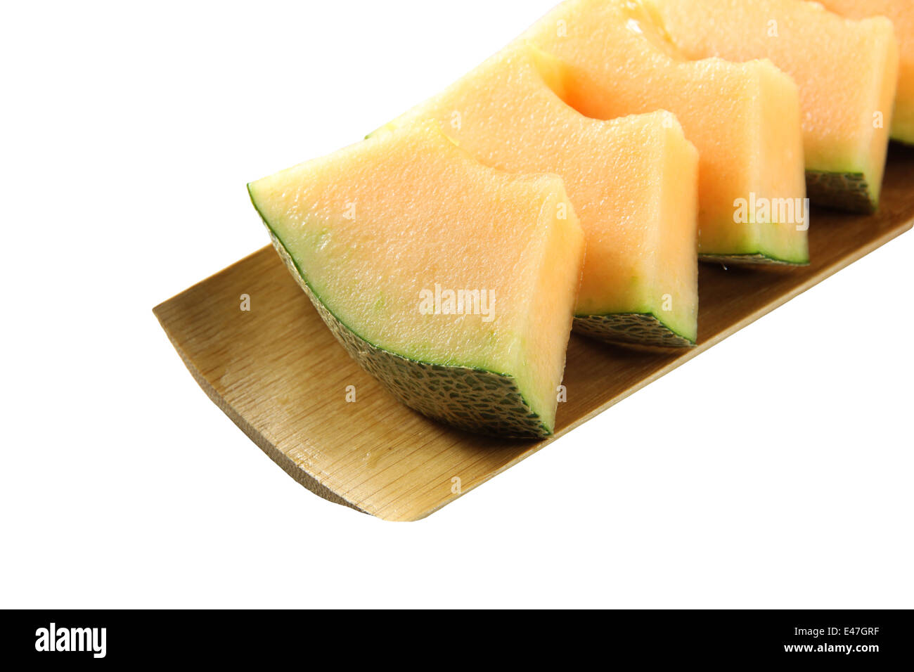 Il melone Cantalupo isolato in bambù piatto su sfondo bianco. Foto Stock