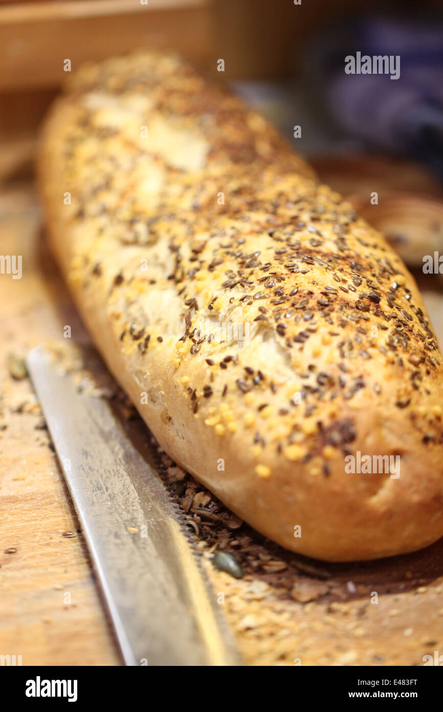 Pasta di pane cotto al forno con semi di papavero e coltello di taglio sul tagliere. Foto Stock