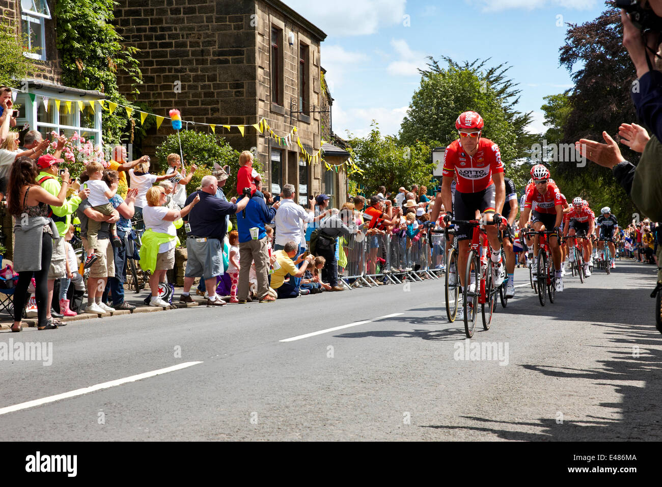 Addingham, Yorkshire. Il 5 luglio 2014. I ciclisti nella prima tappa del Tour de France passano attraverso il villaggio dello Yorkshire di Addingham, con immensa folla festante e sole. Credito: Christina Bollen/Alamy Live News Foto Stock