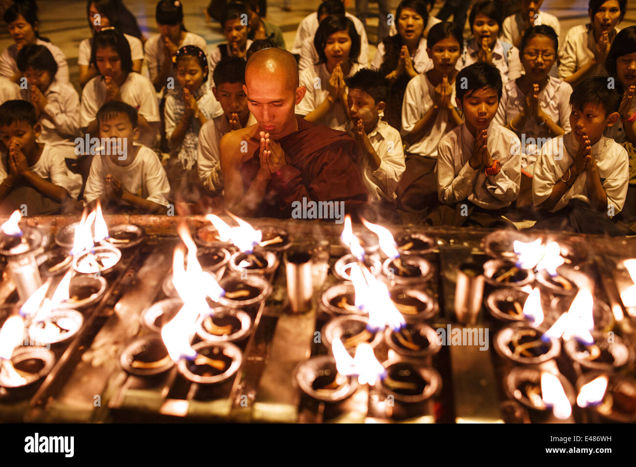 Un gruppo di bambini della scuola di pregare con un monaco buddista a Shwedagon pagoda in Yangon MYANMAR Birmania Foto Stock