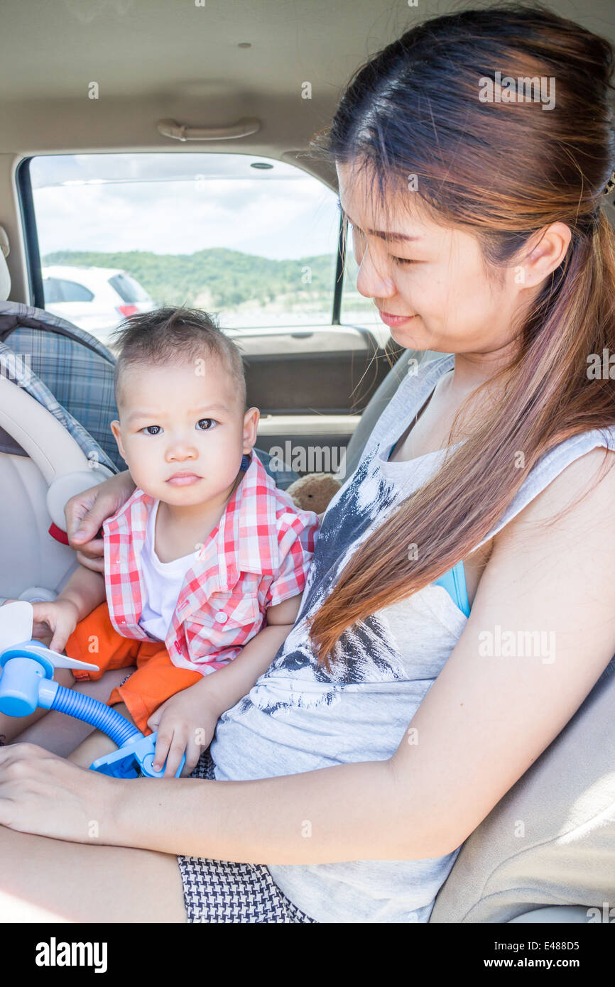 Asian ragazzo seduto in macchina con sua madre, stock photo Foto Stock