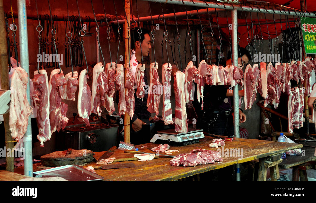 Pengzhou, Cina : lastre di maiale appeso al ferro ganci di carne in una  macelleria a lungo Xing marketplace Foto stock - Alamy