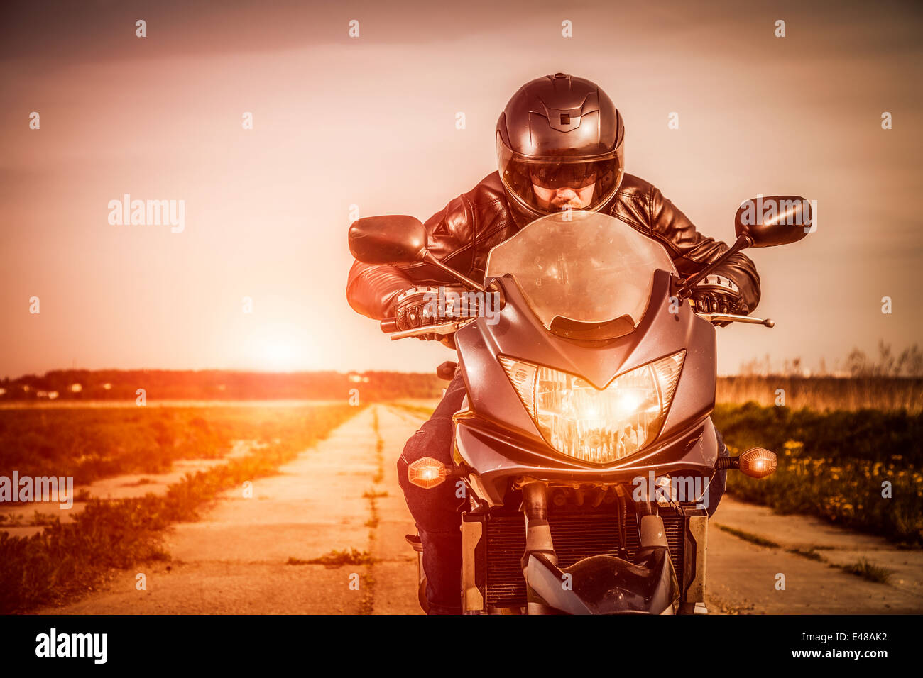 Biker in casco e giacca di pelle racing su strada Foto Stock Biker in casco e giacca di pelle racing su strada Foto Stock