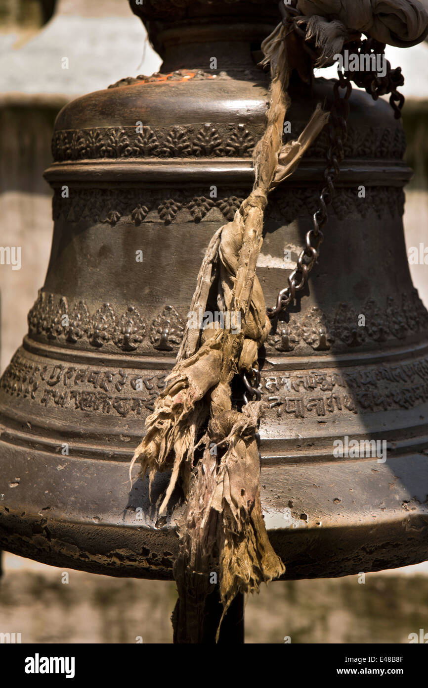 Il Nepal, Kathmandu, Tempio di ottone decorato a campana con il testo in script nepalese Foto Stock