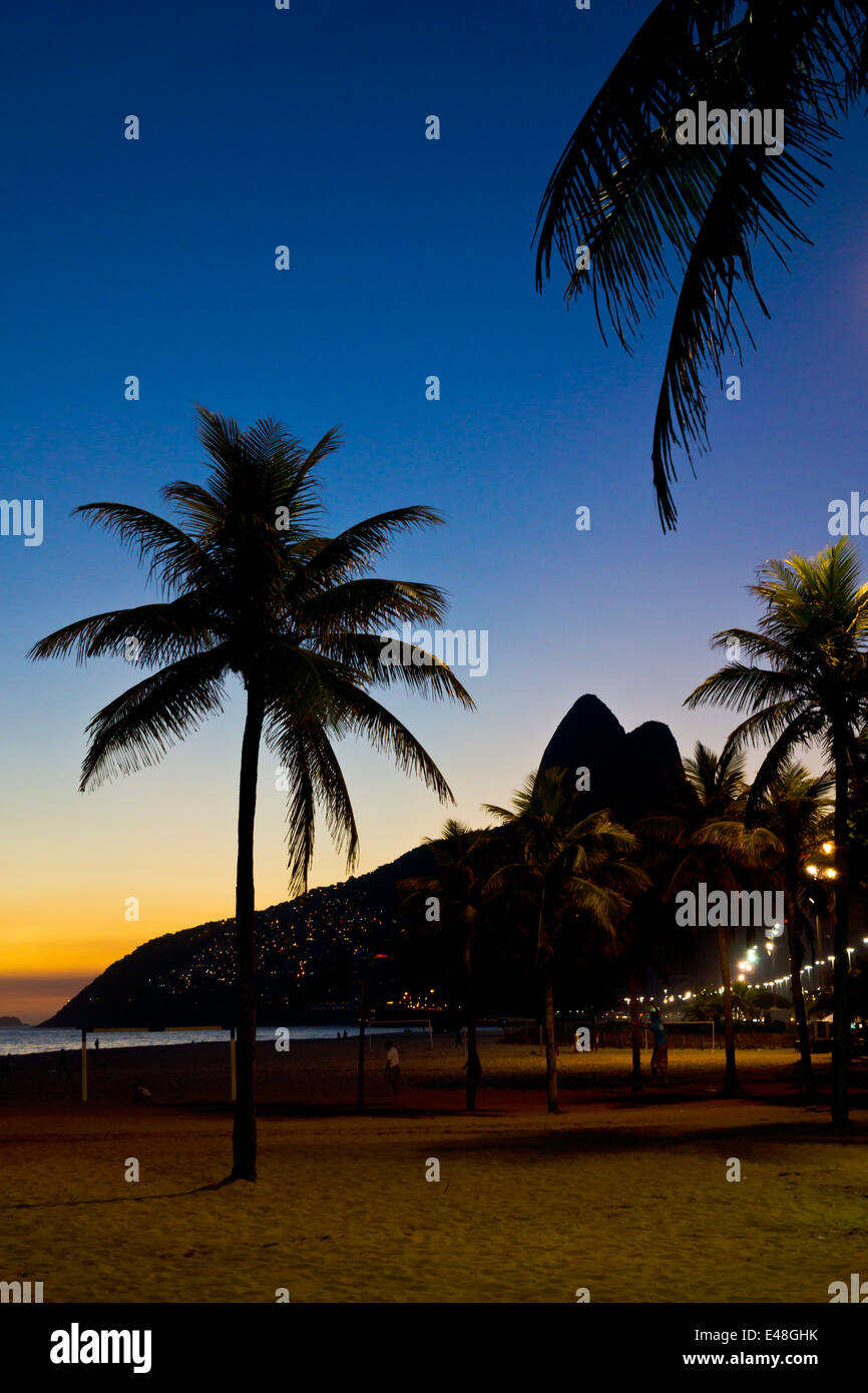 Rio de Janeiro silhouette vista della spiaggia di Ipanema contro le palme e colline chiamate Dois Irmaos Foto Stock