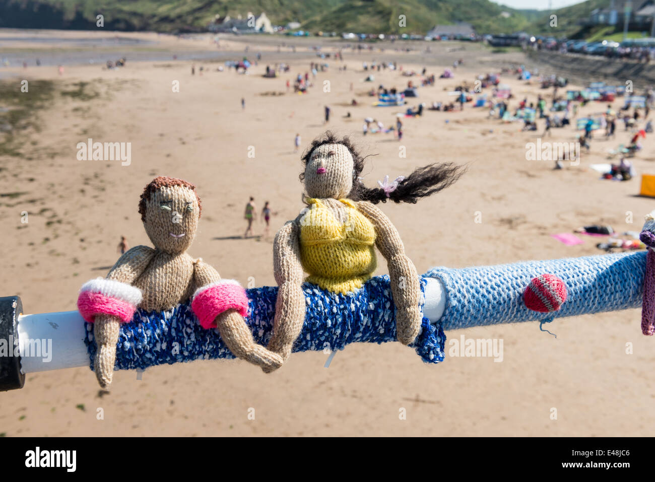 Due bambole in maglia su un molo sulla spiaggia Foto Stock