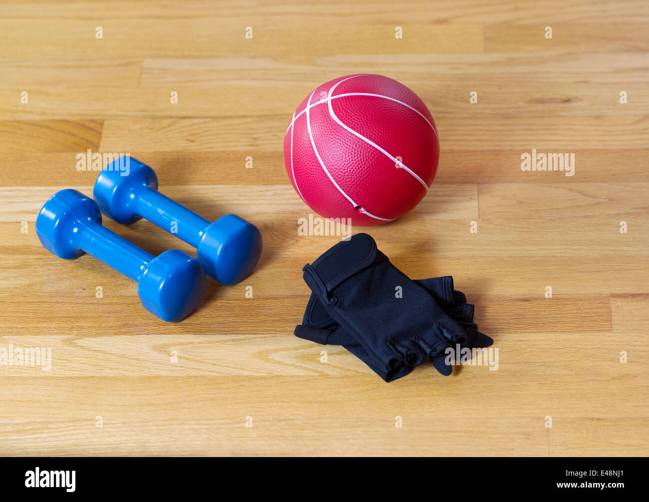 Guanti da allenamento, pesi e peso palla giacente su legno pavimento Palestra Foto Stock