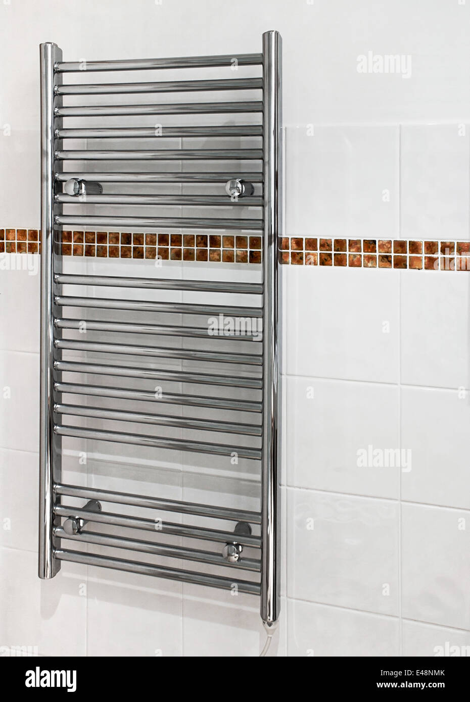 Chrome portasciugamani riscaldato che serve ad un duplice scopo come un radiatore e asciugamani in bagno moderno. Foto Stock