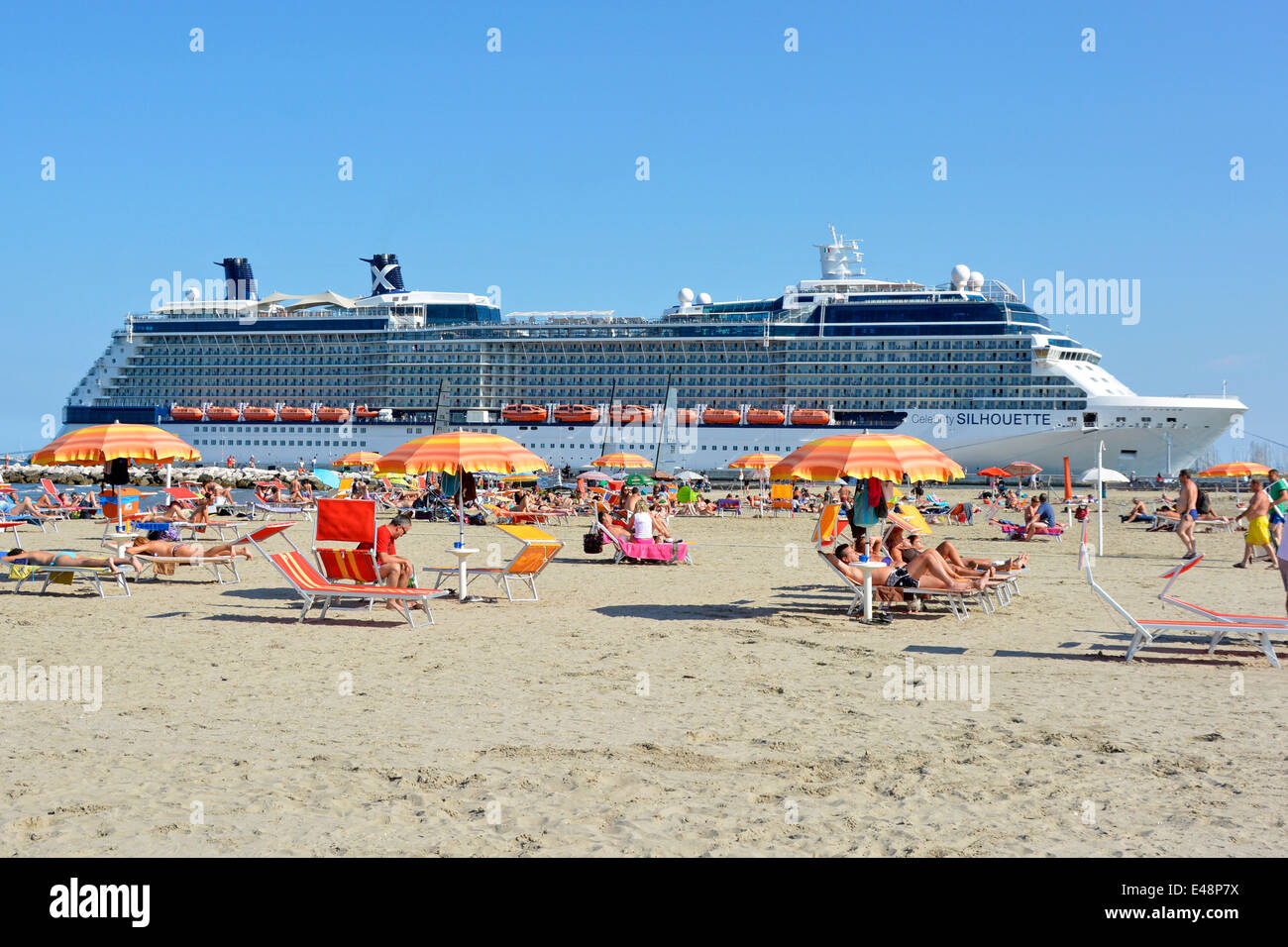 Lettini e ombrellone ombrelloni sabbia italiana vacanza familiare spiaggia nave da crociera transatlantico Celebrity Silhouette a Ravenna Emilia Romagna Italia Foto Stock