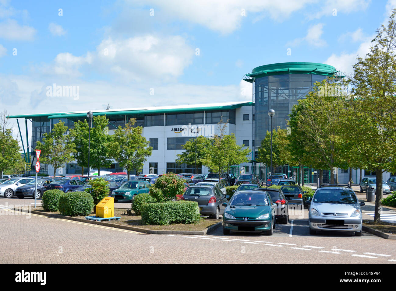 Amazon firma il logo sul centro di distribuzione del magazzino e sul personale degli uffici parcheggio auto (targhe oscurate) Ridgmont Bedfordshire Inghilterra Regno Unito Foto Stock
