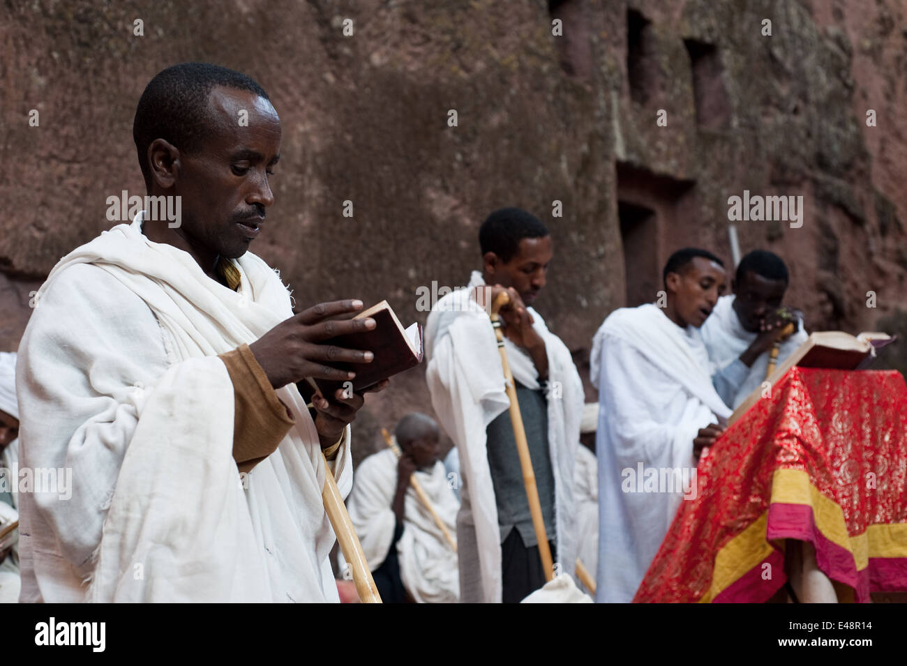 I sacerdoti ortodossi e studenti religiosi dicendo la massa in una roccia scavate chiesa ( Etiopia) Foto Stock