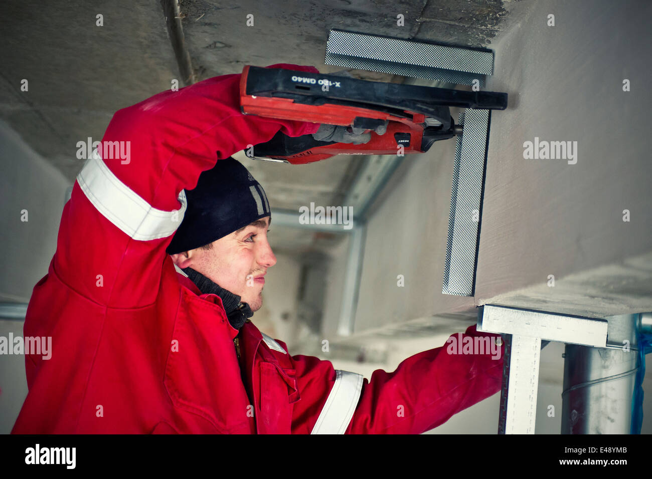 Uomo al lavoro con una pistola sparachiodi Foto Stock