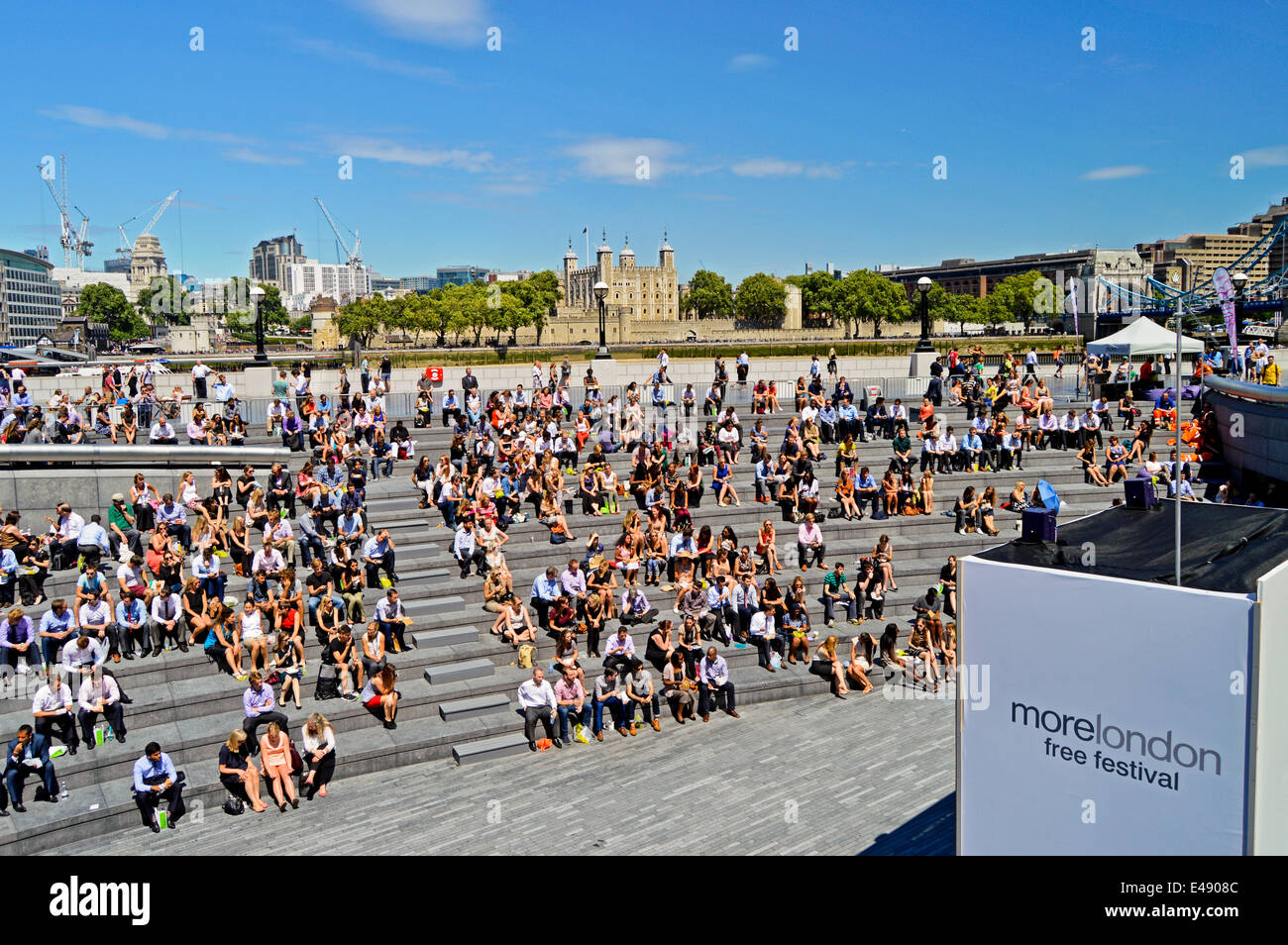 Gruppo di lavoratori di ufficio durante la pausa pranzo a più Londra Riverside che mostra la Torre di Londra in background, London, England, Regno Unito Foto Stock