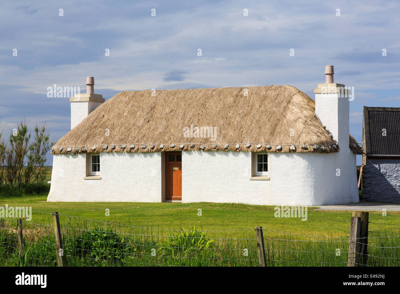 Vecchio e restaurato con tetto di paglia di Croft cottage tradizionale con pareti limewashed. Lochdar Sud Uist Ebridi Esterne Western Isles della Scozia UK Foto Stock