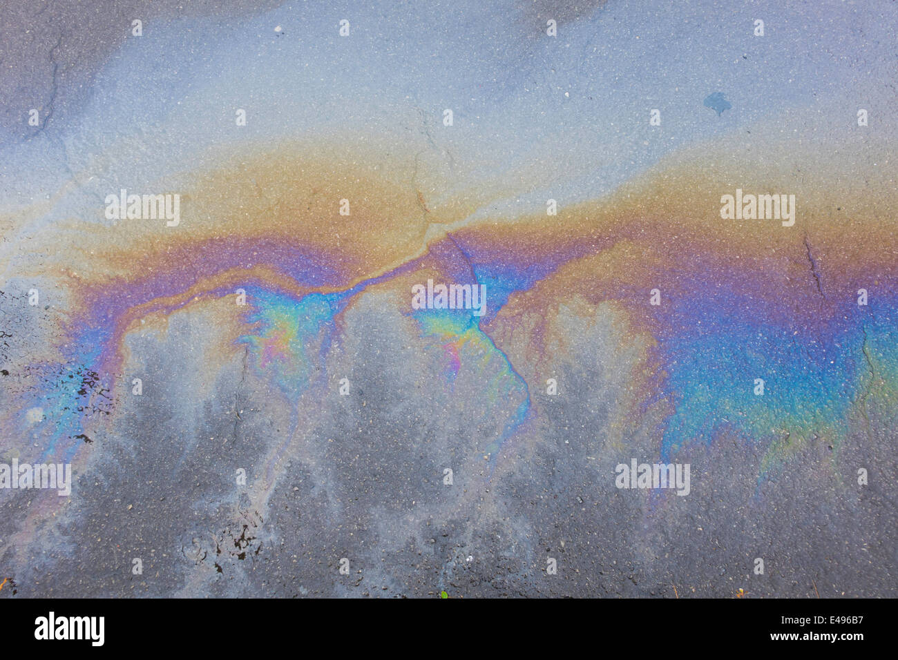 Color arcobaleno fuoriuscite di olio su asfalto bagnato la superficie stradale Foto Stock