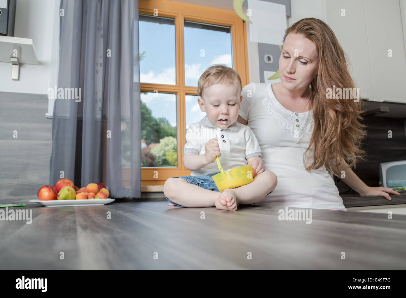 Donna con un 1,5 anni vecchio ragazzo in cucina Foto Stock
