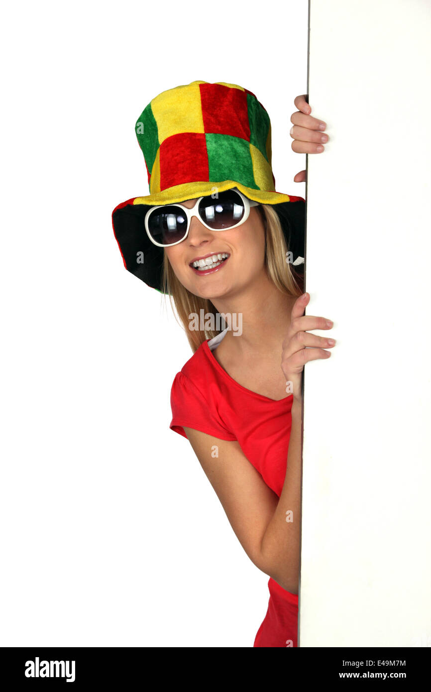 Donna che indossa un buffo cappello e occhiali da sole Foto Stock