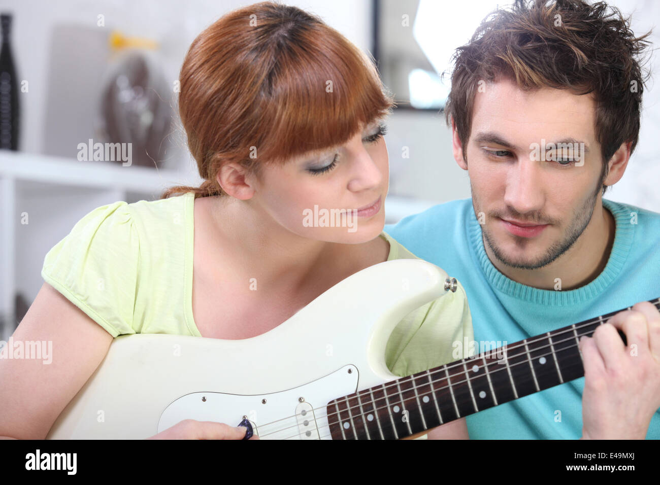 Uomo di insegnamento di una donna a suonare la chitarra Foto Stock