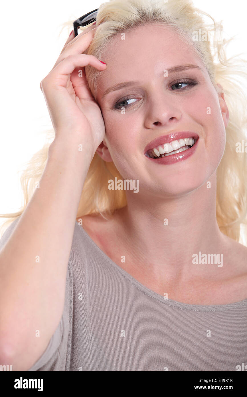 Donna sorridente tenendo i suoi occhiali da sole spento Foto Stock