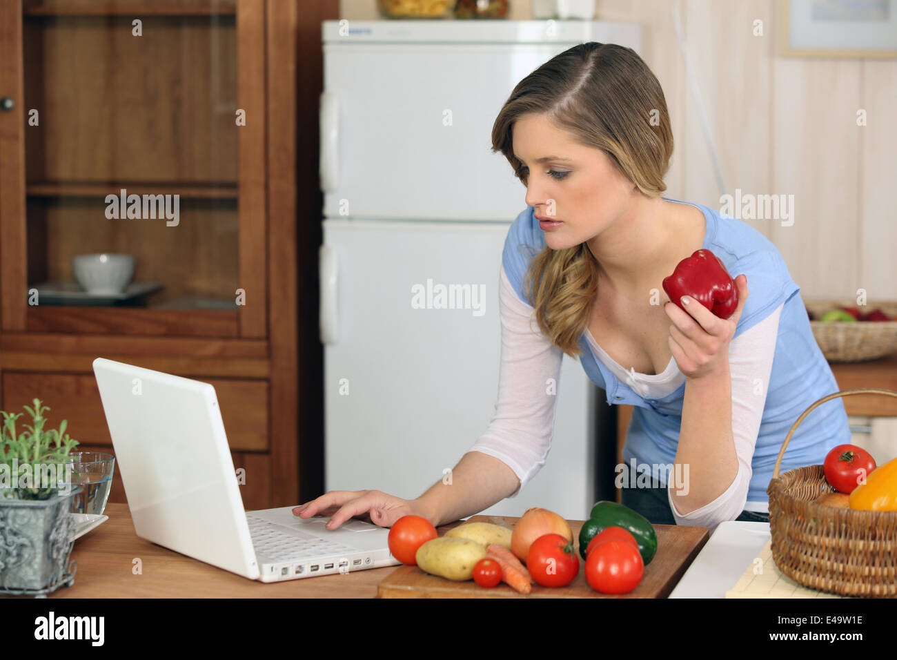Giovane donna cottura a casa Foto Stock
