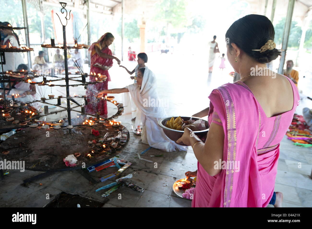 Donna indù che trasportano puja offerte al Signore siva, e altri accendendo candele in Sivadol Mandir, Sivasagar, Assam, India, Asia Foto Stock