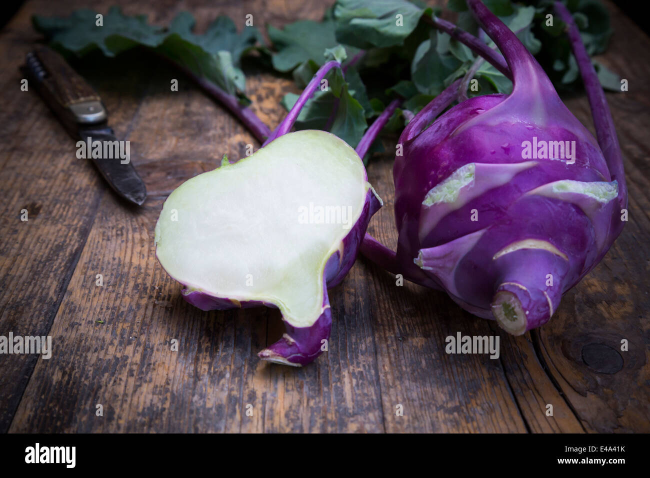 Intero e una metà blu cavoli rapa, Brassica oleracea var. gongylodes L. e coltello in legno scuro Foto Stock
