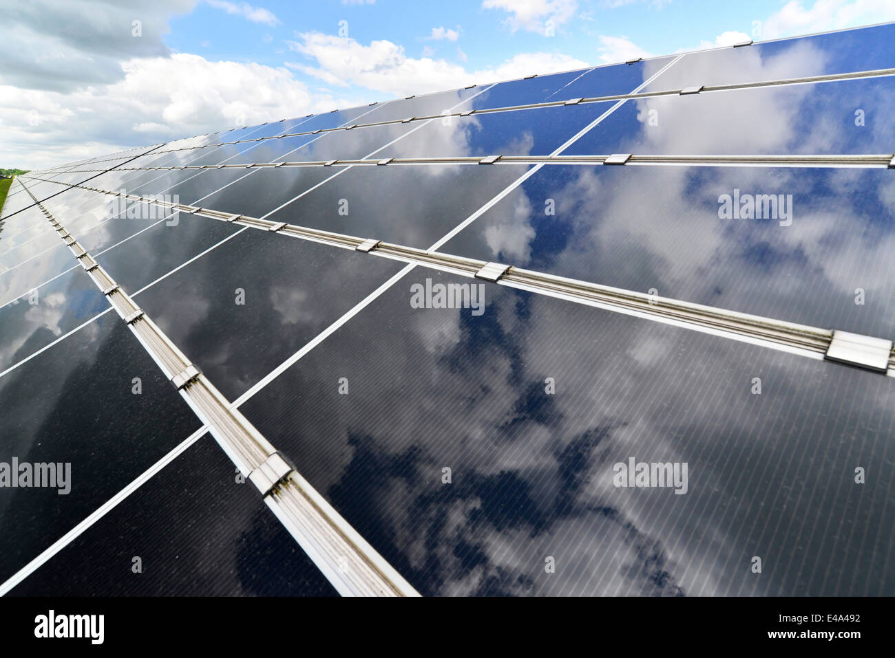 Germania, celle fotoelettriche della centrale solare con riflessi di nuvole, vista parziale Foto Stock