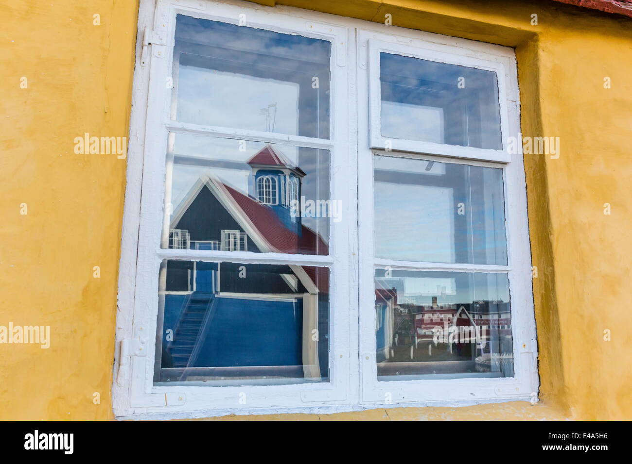 Chiesa riflessa nel dipinto luminosamente finestra di casa in Sisimiut, Groenlandia, regioni polari Foto Stock