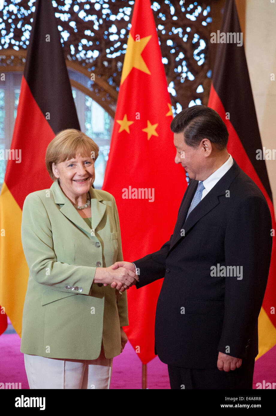 Pechino, Cina. 7 Luglio, 2014. Il cancelliere tedesco Angela Merkel, (L), e il presidente cinese Xi Jinping agitare le mani prima di un incontro presso il Diaoyutai State Guesthouse a Pechino in Cina 07 luglio 2014. Merkel è su una tre giorni di visita in Cina e si prevede di tenere colloqui con funzionari cinesi a rafforzare i legami tra i due paesi. Foto: KAY NIETFELD/dpa/Alamy Live News Foto Stock