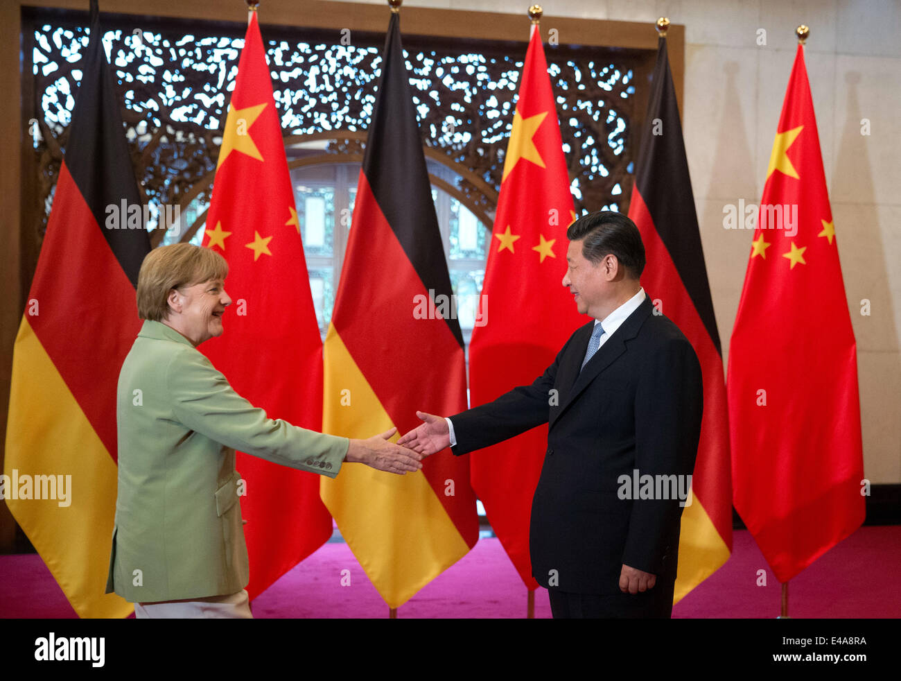 Pechino, Cina. 7 Luglio, 2014. Il cancelliere tedesco Angela Merkel, (L), e il presidente cinese Xi Jinping agitare le mani prima di un incontro presso il Diaoyutai State Guesthouse a Pechino in Cina 07 luglio 2014. Merkel è su una tre giorni di visita in Cina e si prevede di tenere colloqui con funzionari cinesi a rafforzare i legami tra i due paesi. Foto: KAY NIETFELD/dpa/Alamy Live News Foto Stock