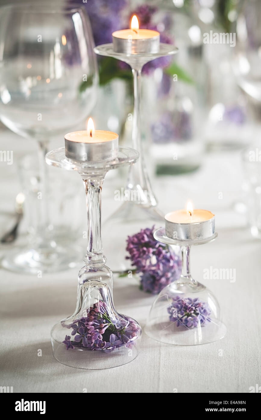 Decorazioni per la tavola con candele di tè, bicchieri e lilla