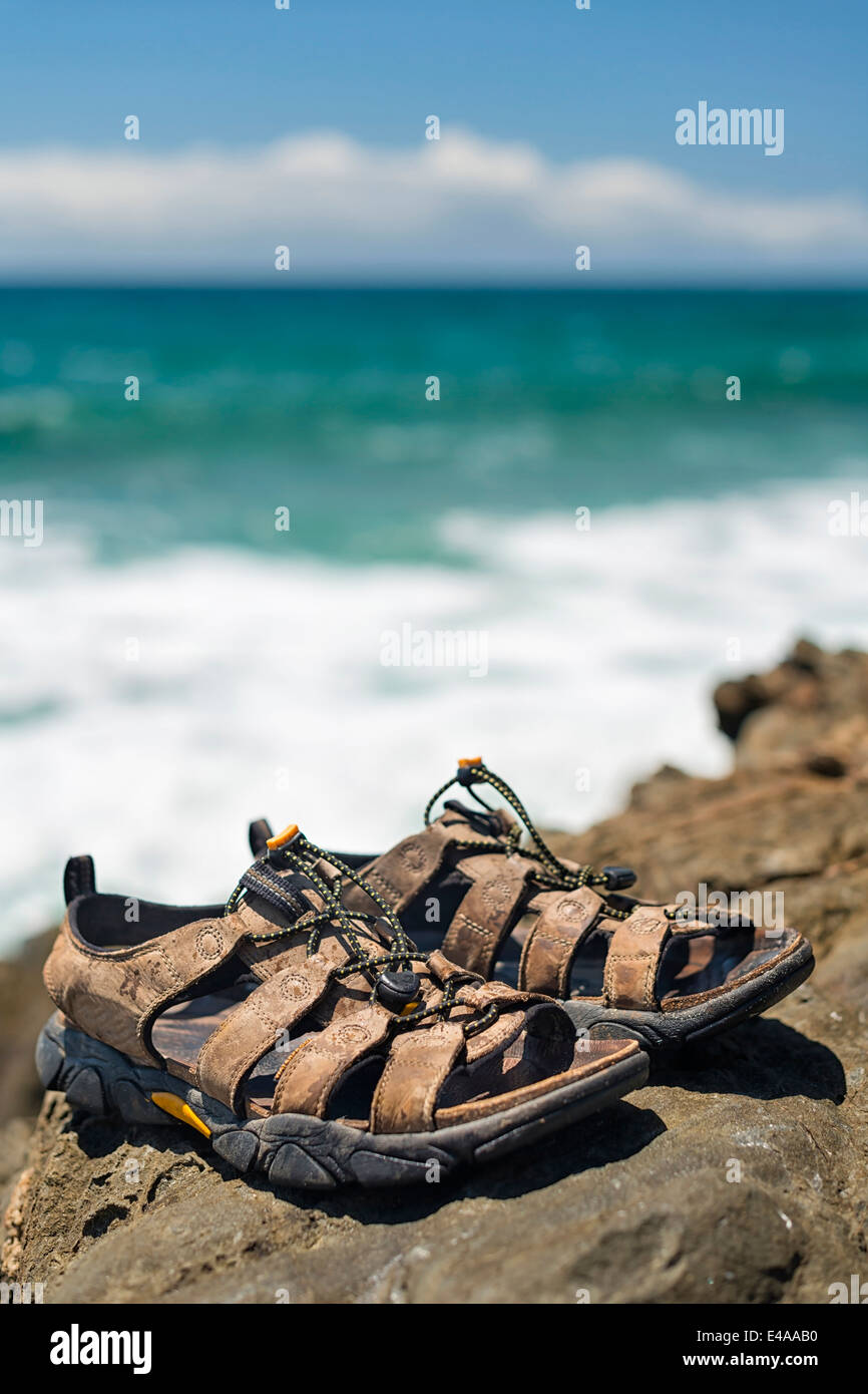 Australia, Nuovo Galles del Sud, Byron Bay, rotte capo riserva naturale, trekking sandali su rocce con le onde che si infrangono dietro Foto Stock