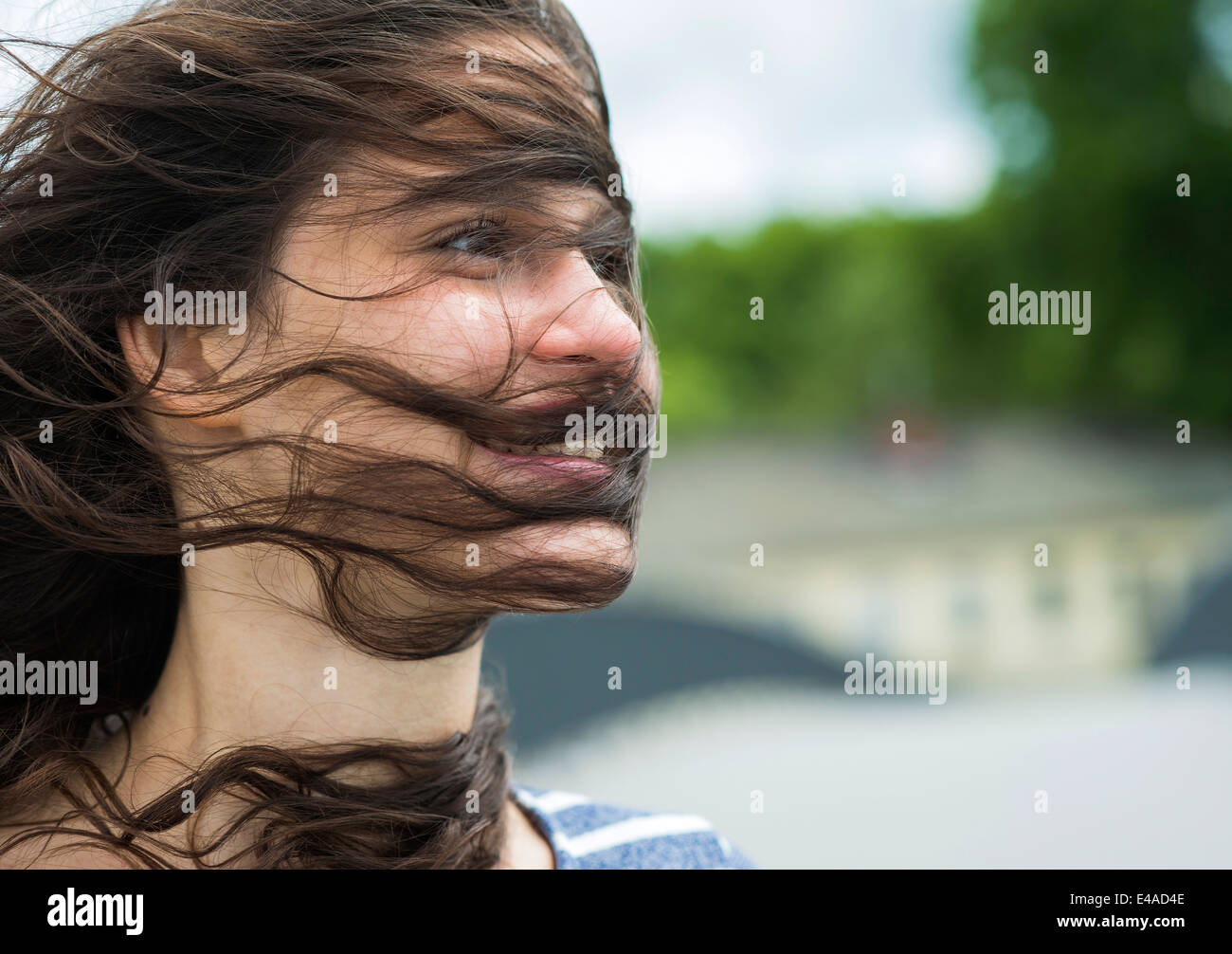 Ritratto di sorridente giovane donna con ciocche di capelli nel suo viso Foto Stock