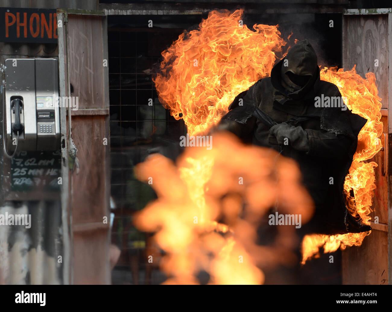 Uno stunt man on Fire corre attraverso il cosiddetto Vulkan Arena durante uno stunt show a Babelsberg studios di Potsdam, Germania, 7 luglio 2014. La stunt arena è stato costruito 15 anni fa ed è stato mostra fino a 3.333 mostra con più di 5 milioni di visitatori da allora. Foto: Ralf Hirschberger/dpa Foto Stock