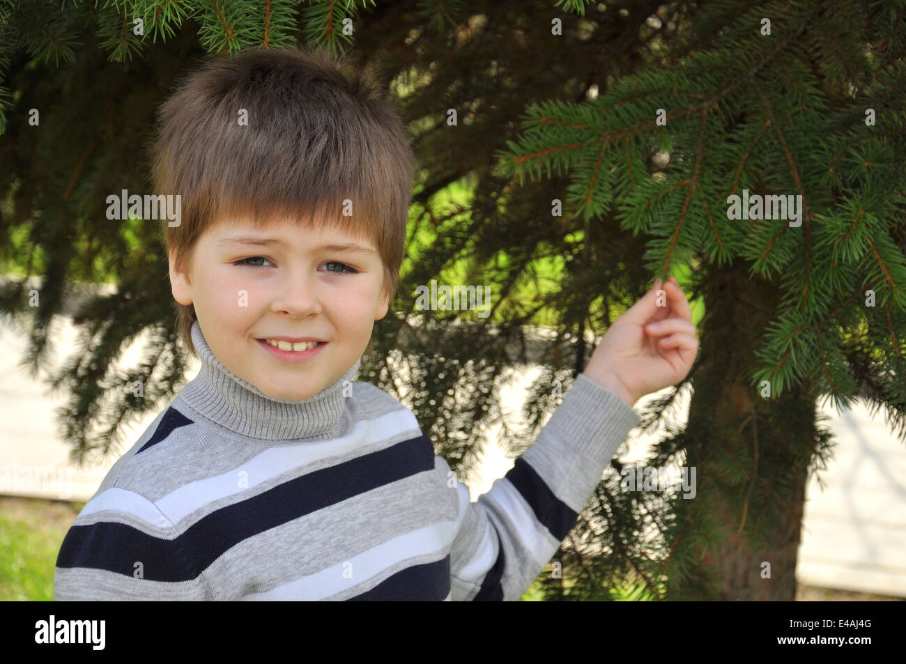 Bambino ritratto uno a otto anni vale la pena turtleneck cardigan maglione stripe parchi a strisce verdi giardini di capelli biondi guarda guarda da Foto Stock