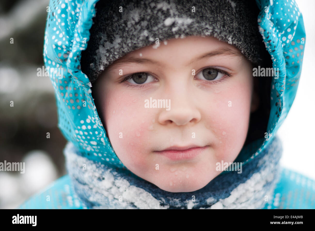 Ritratto ragazzo Bambino 7 8 9 anno di neve in inverno scende umido giacca sciarpa cofano uno carino bello grave in Russia freddo congelamento di brina Foto Stock