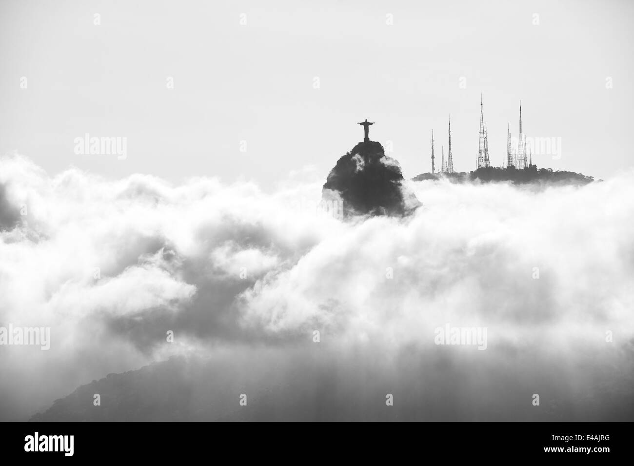 Monte Corcovado Cristo Redentore in piedi sopra incandescente di vorticazione nuvole di nebbia di Rio de Janeiro in Brasile Foto Stock