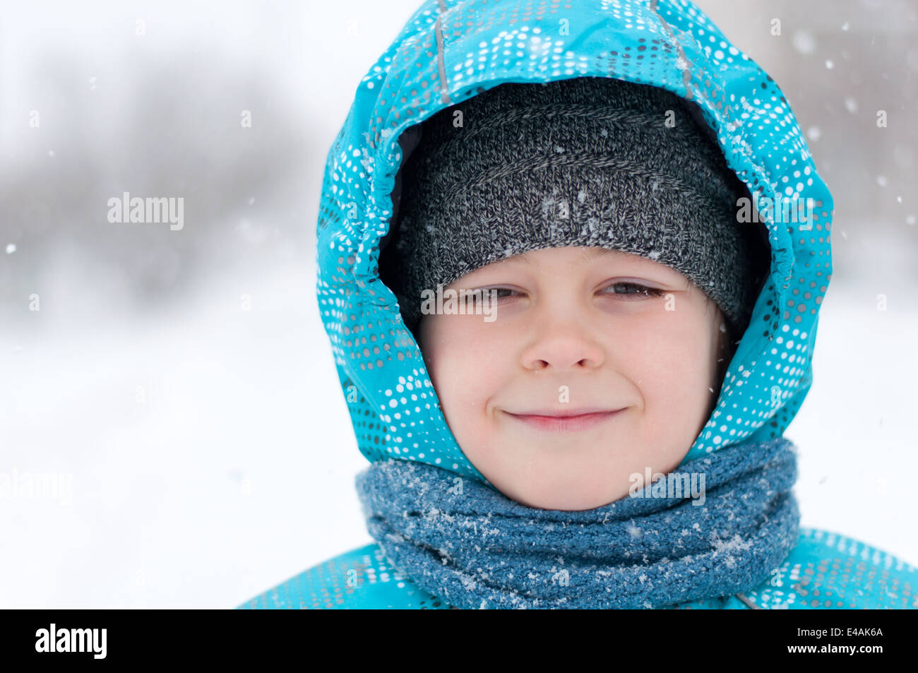 Bambino ritratto uno a otto anni abbigliamento invernale blizzard gelo della neve down jacket cofano sciarpa blu freddo giorno guarda a destra la Russia n. Foto Stock
