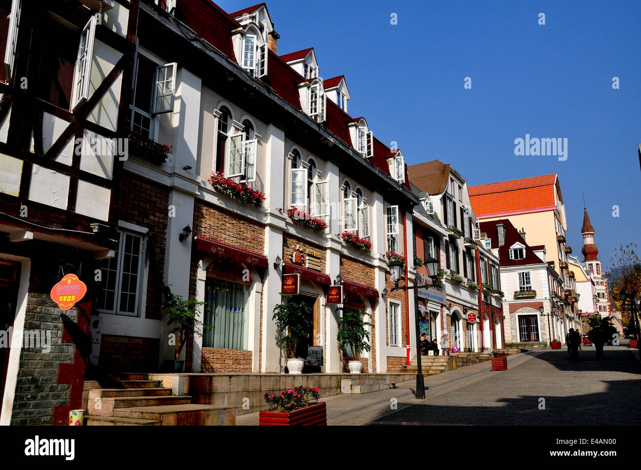 BAI LU, CINA: vista guardando verso nord sulla strada principale del villaggio Sino-French con il suo bel alsaziano francese Foto Stock