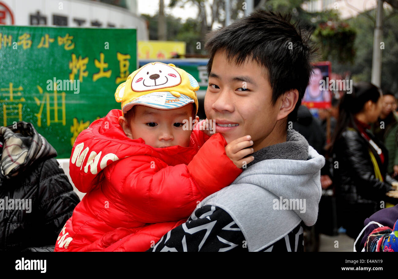 PENGZHOU, CINA: sorridente giovane azienda un giovane ragazzo in un centro commerciale pedonale Foto Stock