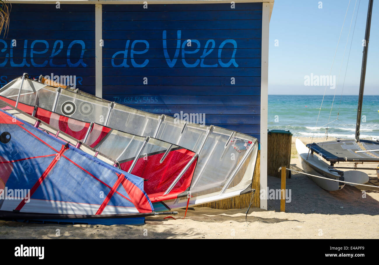 Vele windsurf e catamarano di fronte scuola di surf sulla spiaggia in Spagna Foto Stock