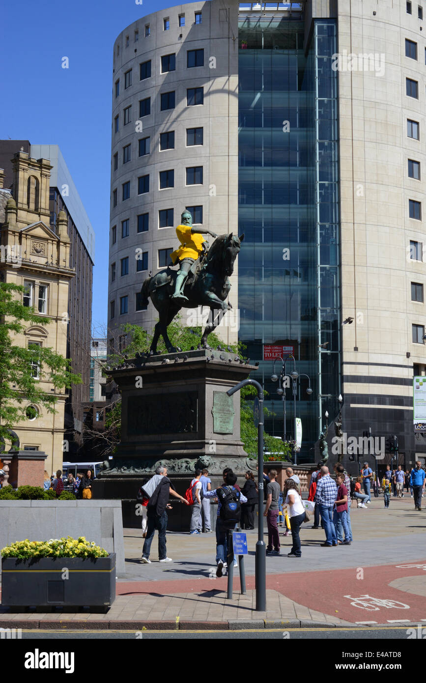 Spettatori passando il principe nero statua indossa maglia gialla che segna l'inizio del tour de France a Leeds Yorkshire Regno Unito Foto Stock