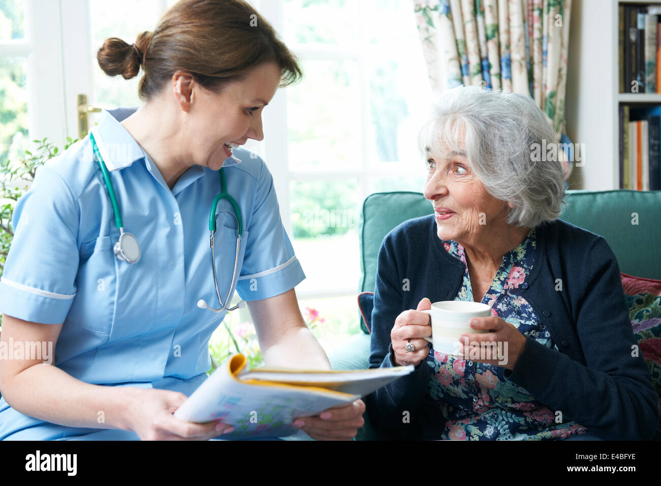 Lavoratore di cura di salute visitando Senior donna a casa Foto Stock