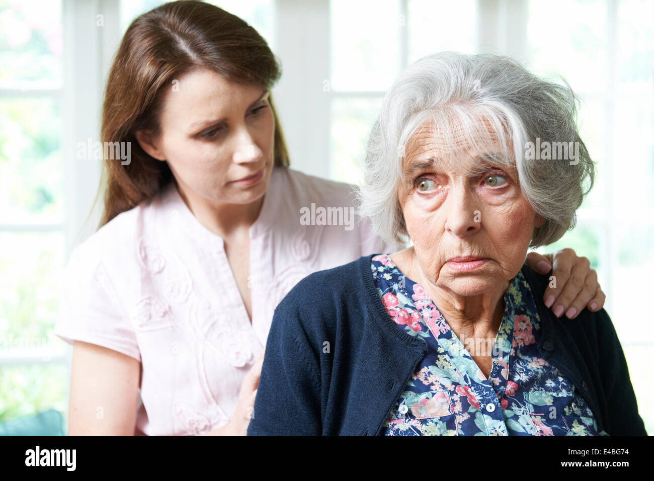 Figlia adulta consolante Senior Madre a casa Foto Stock
