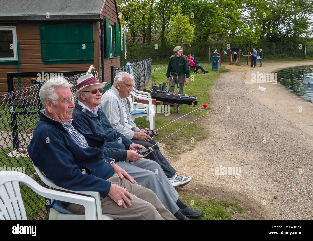 Gli uomini di età matura in un momento di relax a Poole Park Radio Yacht Club, Dorset, England, Regno Unito Foto Stock